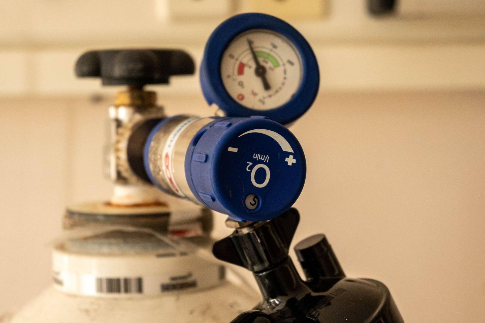 A CPAP machine on a nightstand beside a bed in a home bedroom