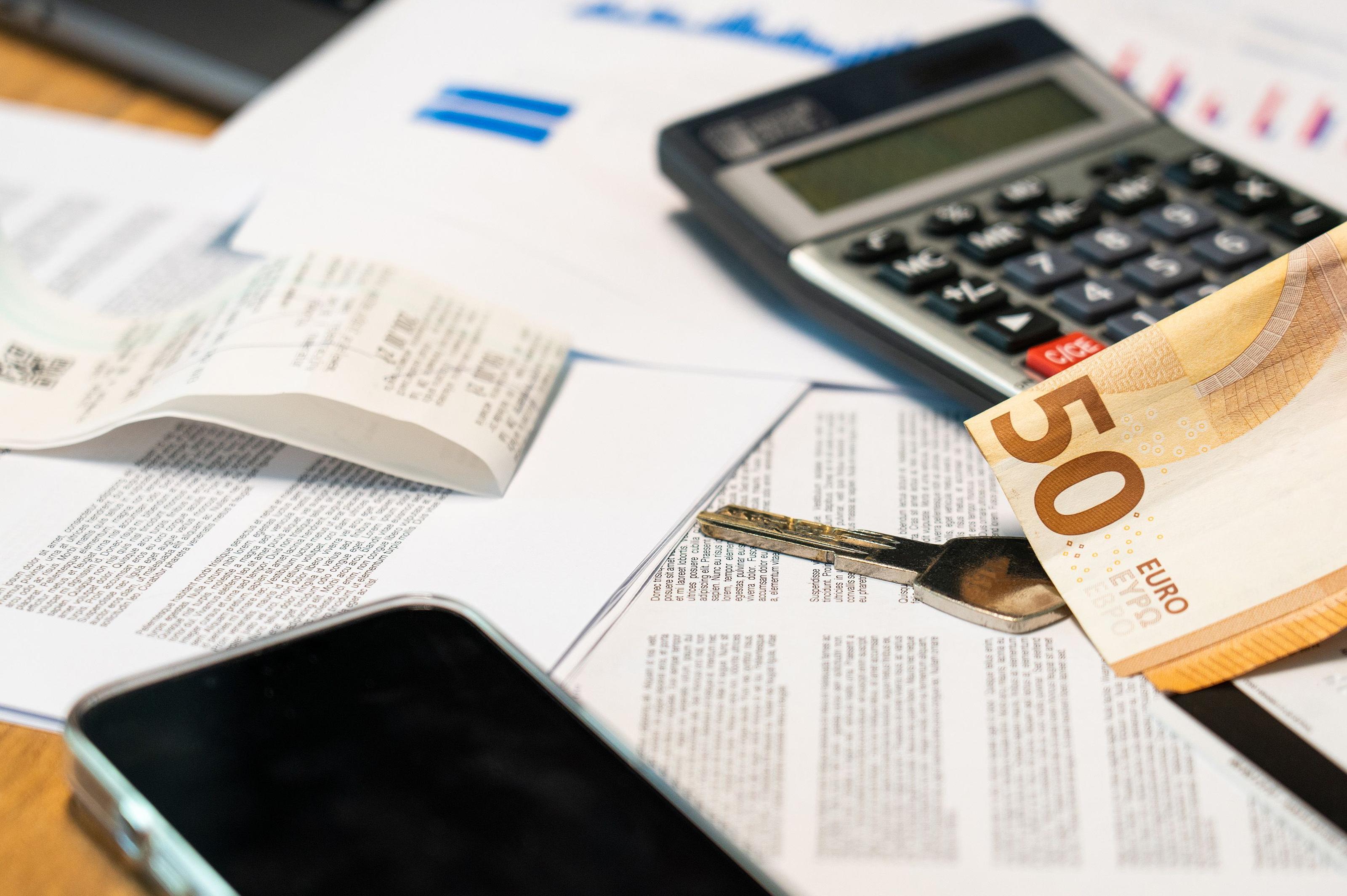 Solar installation cost breakdown documents, invoices and a calculator spread on a desk