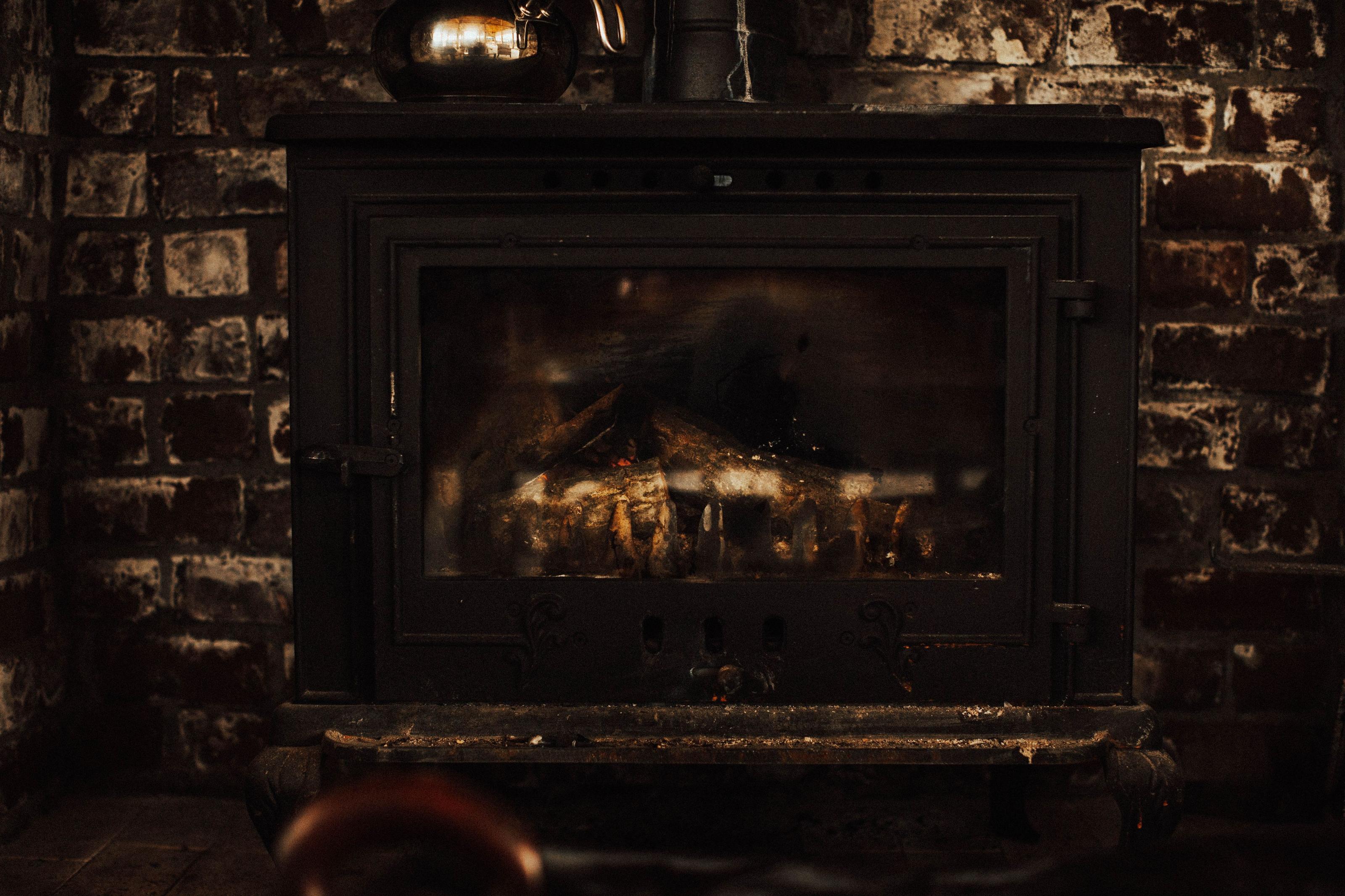 A modern low-emission wood stove burning behind glass in a bright European living room