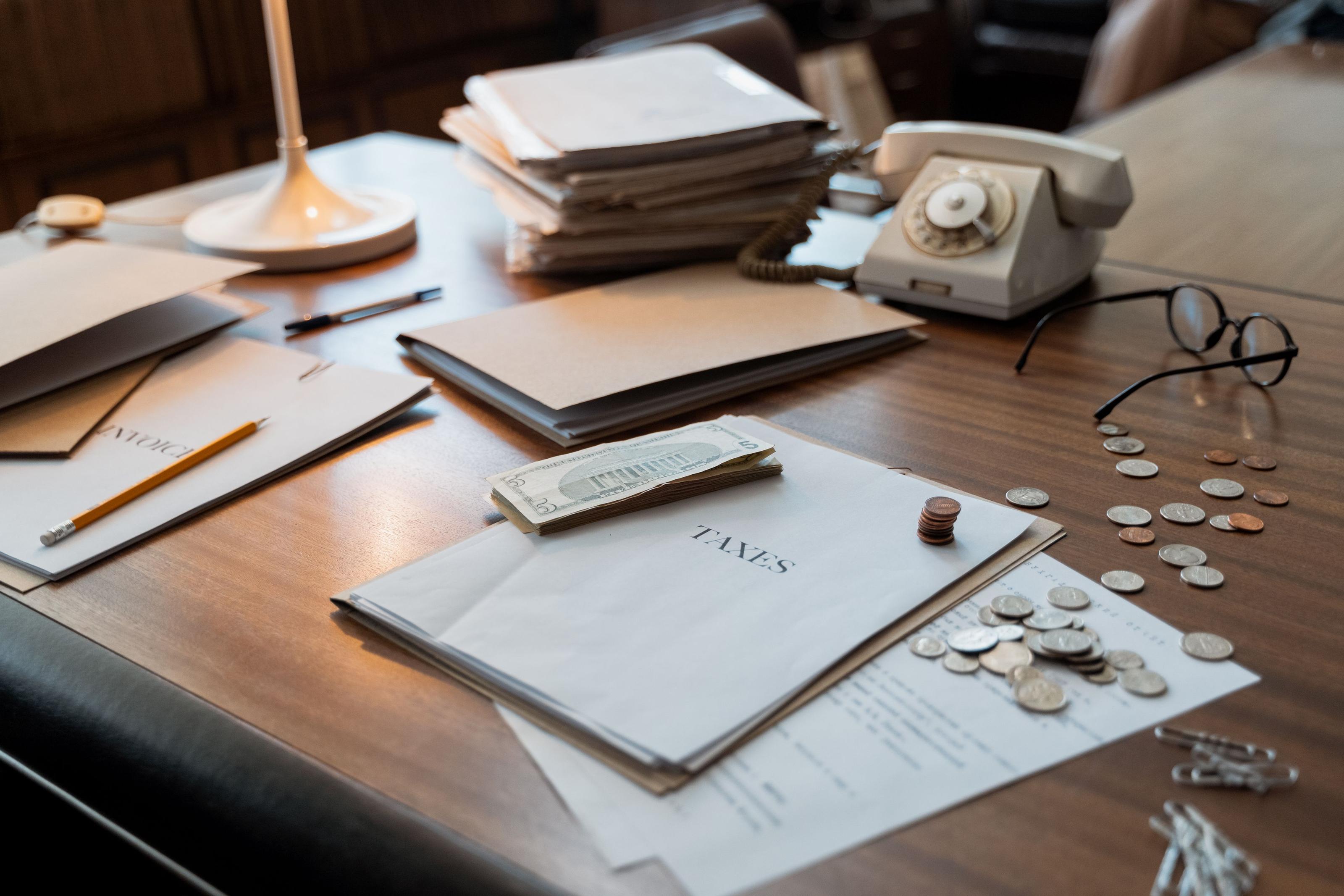 IRS tax forms, a calculator and a small solar panel model on a desk, representing the 2026 off-grid solar tax credit changes