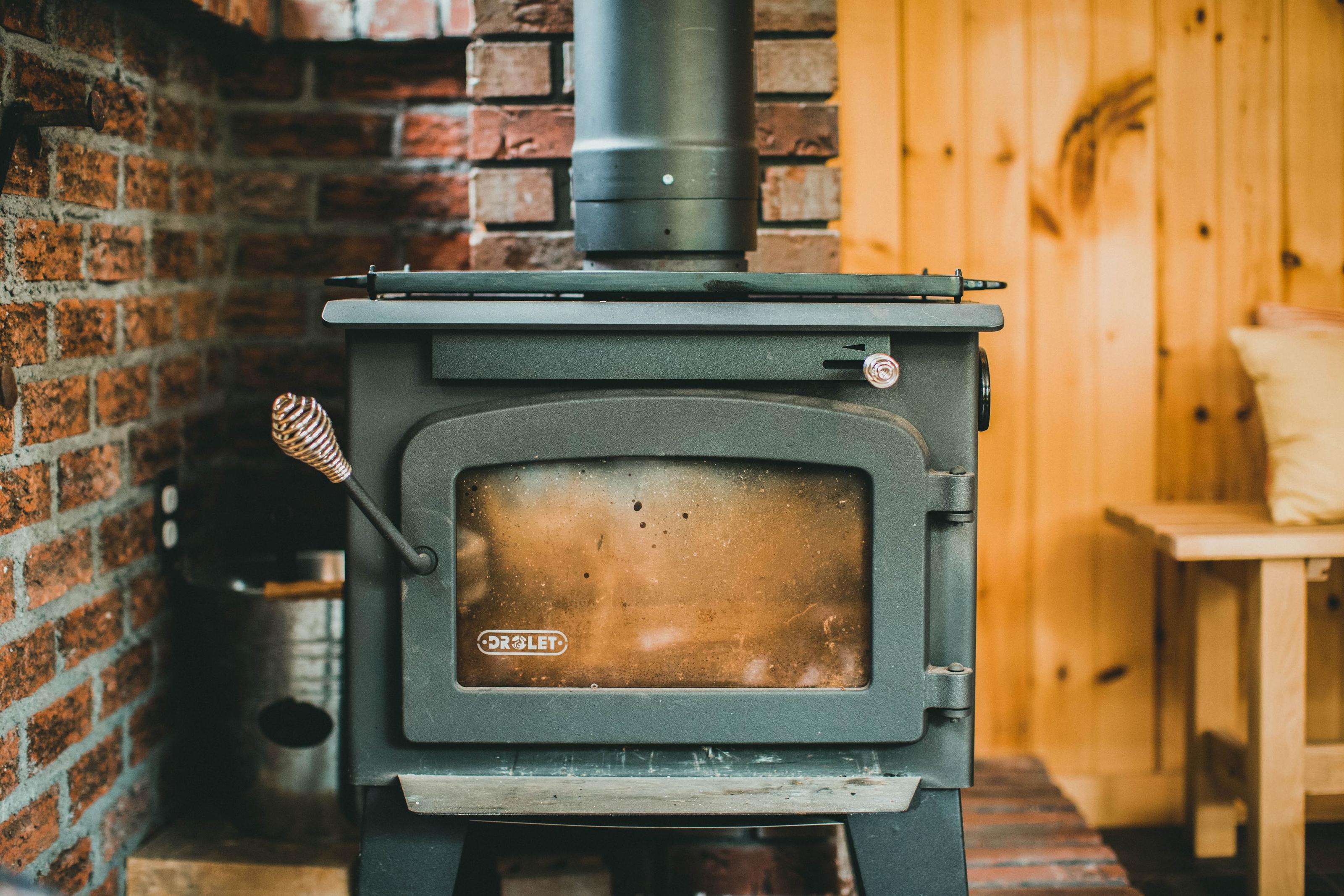 Wood stove burning inside a cozy off-grid cabin on a cold night