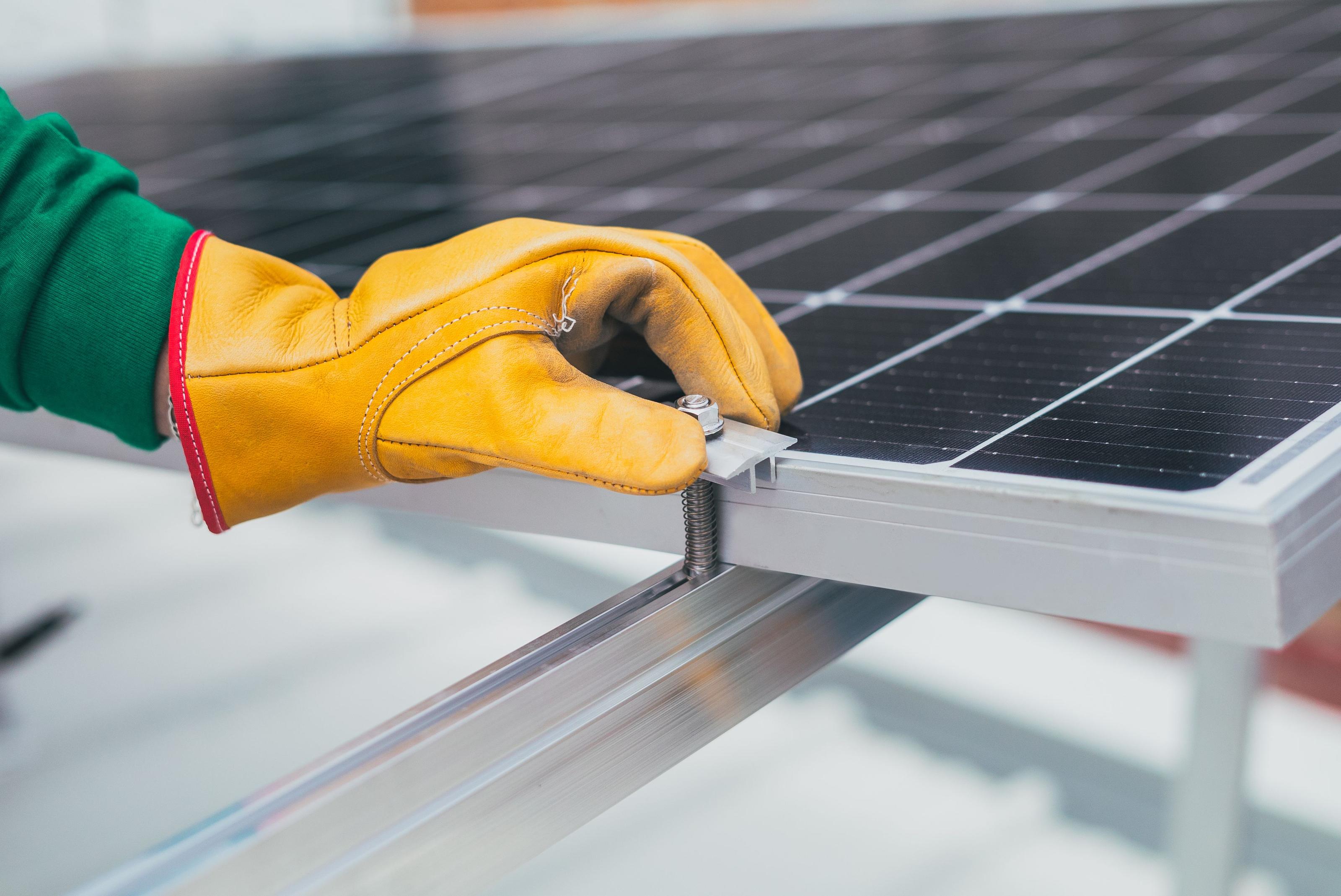Technician installing solar panels on a rooftop for an off-grid power system