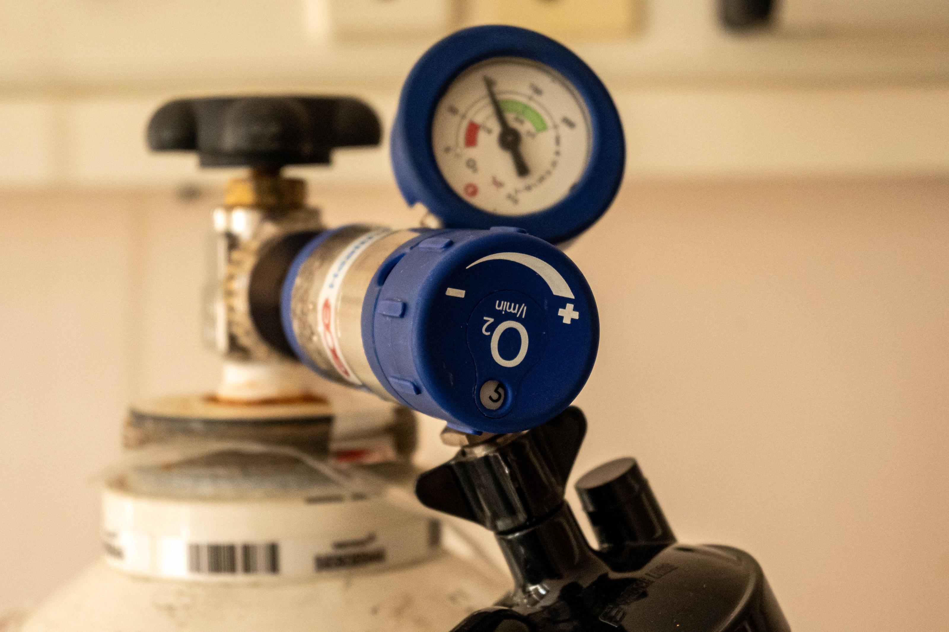 A CPAP machine on a nightstand beside a bed in a home bedroom