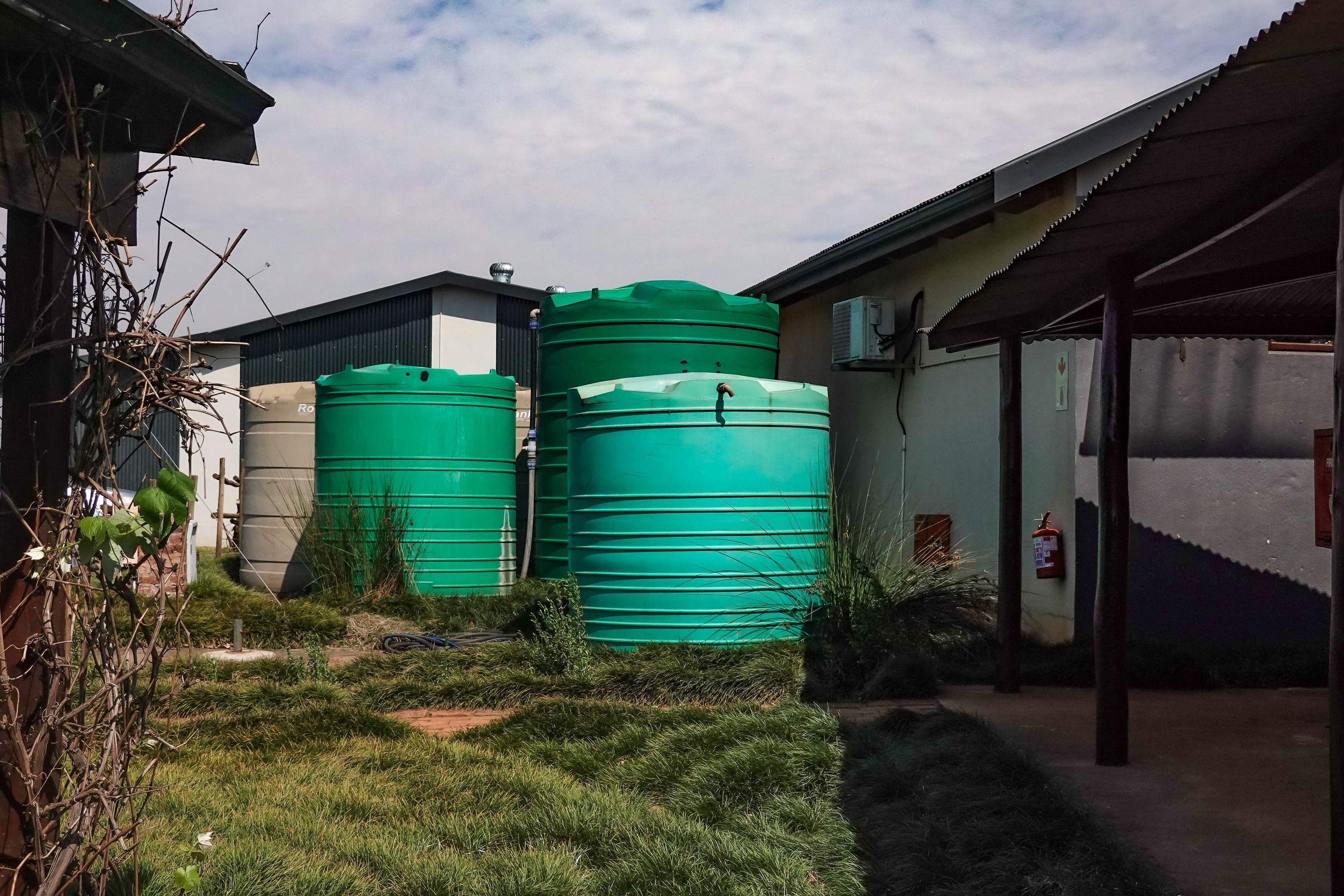 A large off-grid water storage tank on a rural property, plumbed into the home's water system.